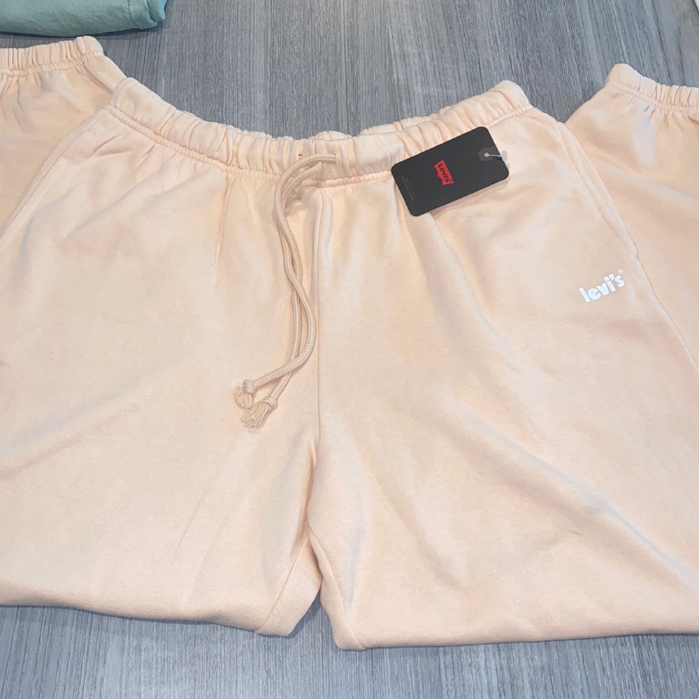 Coral Pink Levi’s Joggers size Large. Stain on one side from pallet wear but NWT
